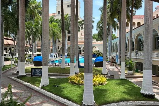 Conjunto residencial con piscina y palmeras