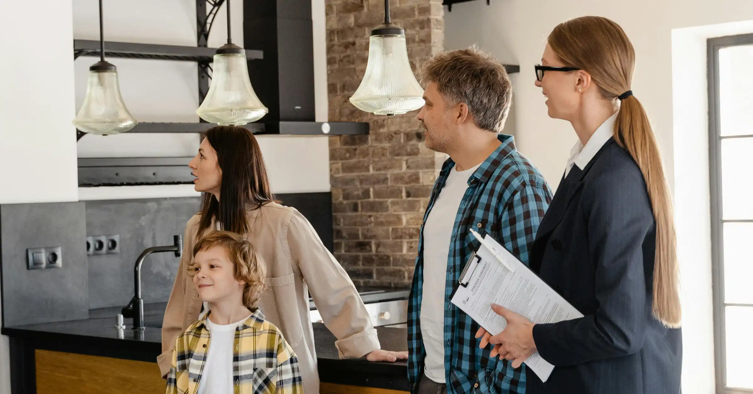 Family touring a home and asking the real estate agent questions.