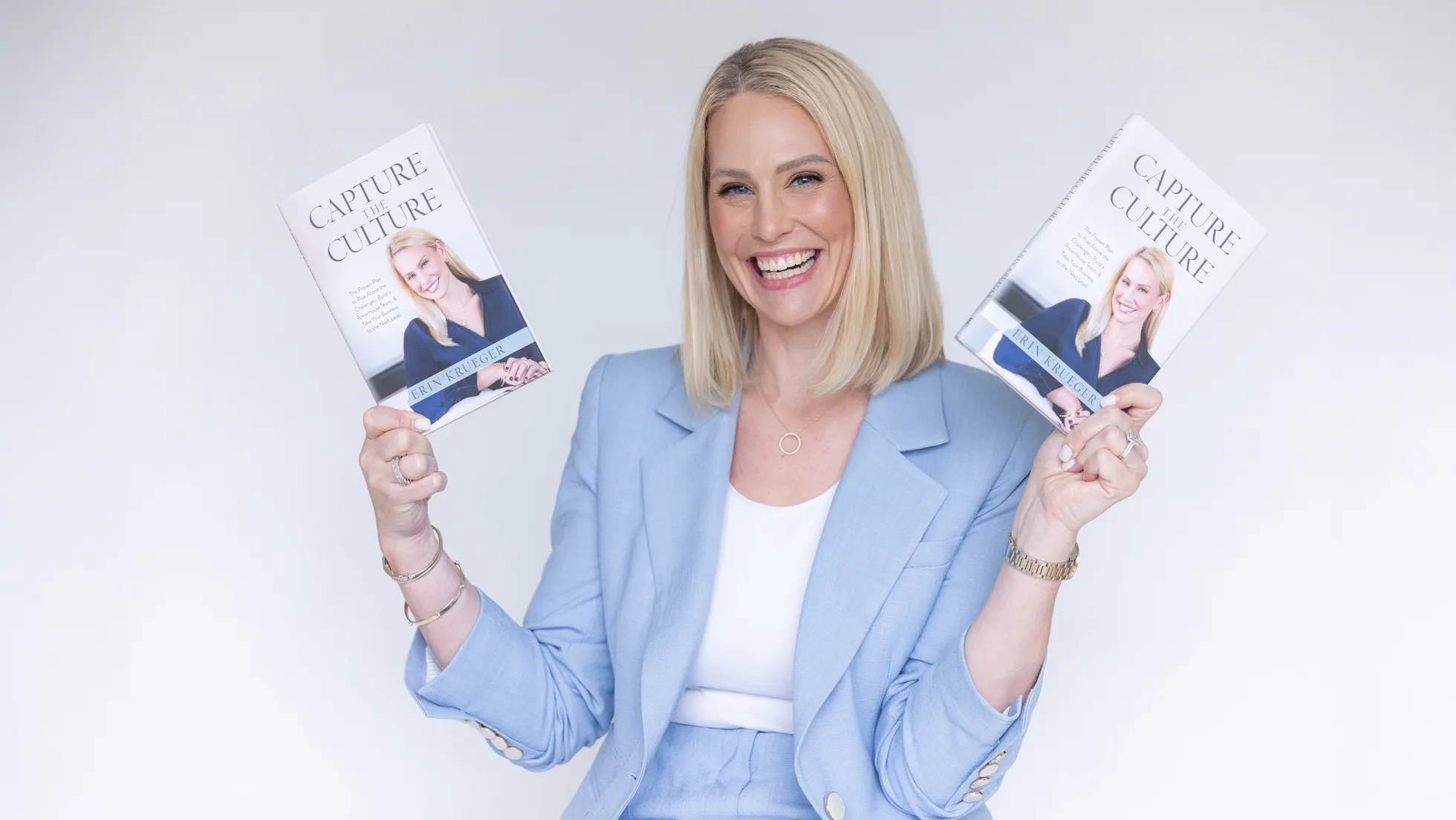 Erin Krueger holding two copies of her book Capture the Culture