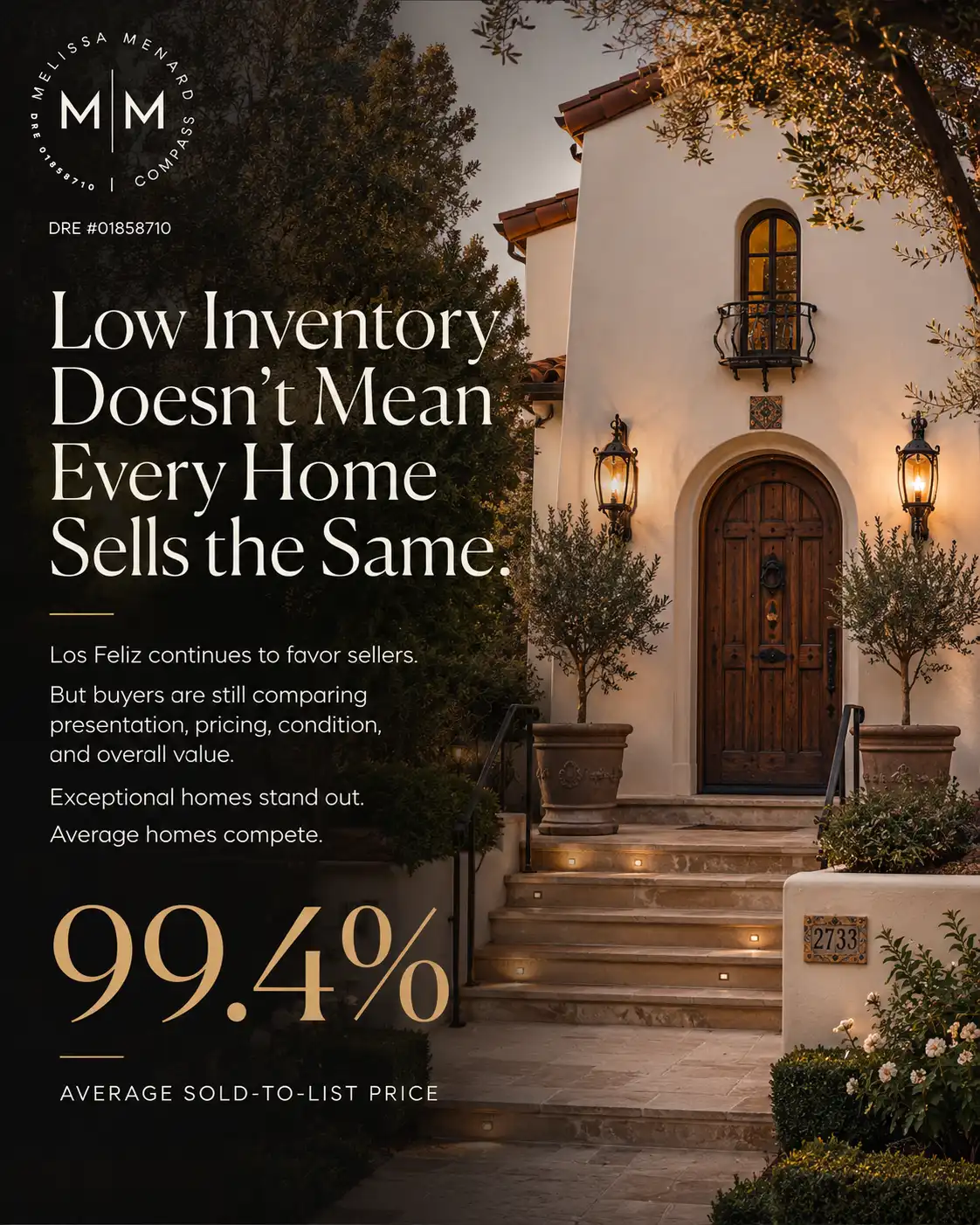 Front entryway of a stucco house featuring tiered stone steps, an arched solid wood door, and exterior wall sconces.