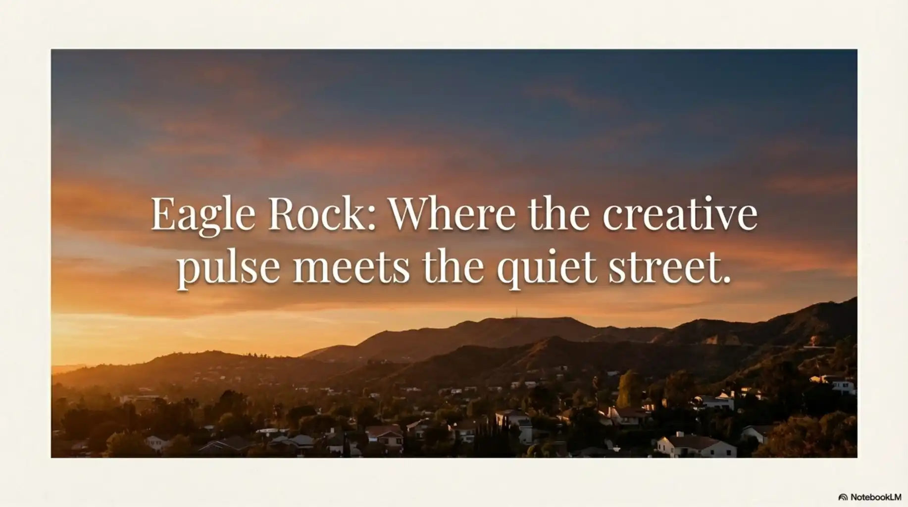 Elevated view of a residential valley with hills in the background under an orange sunset sky.