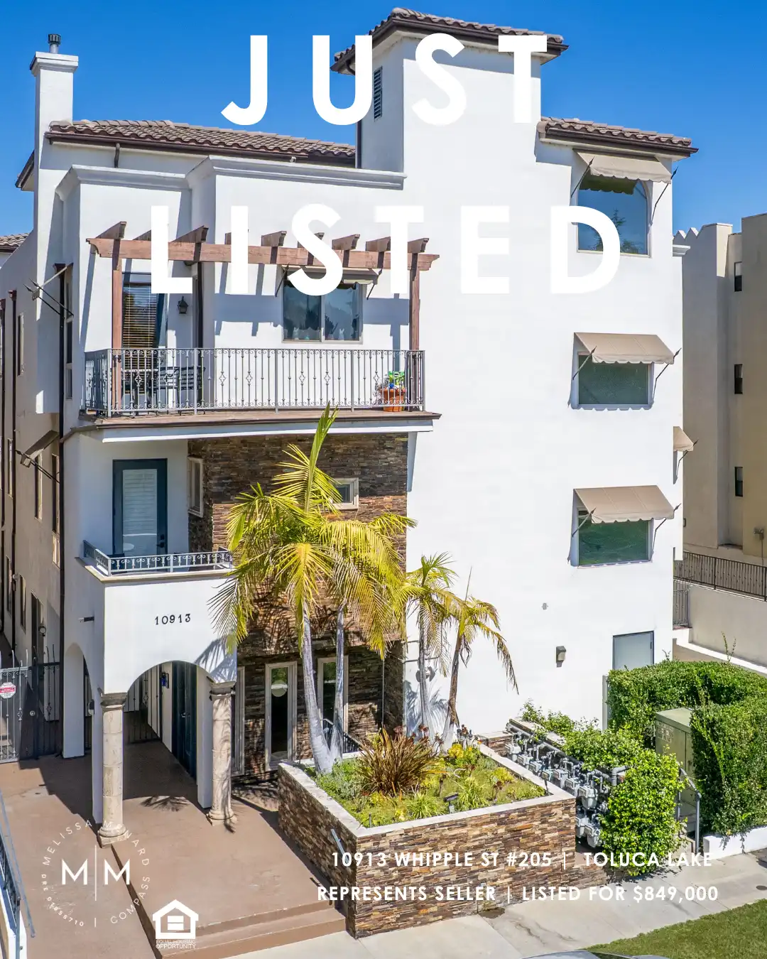 White stucco building exterior with stone veneer accents, balconies, and palm trees.