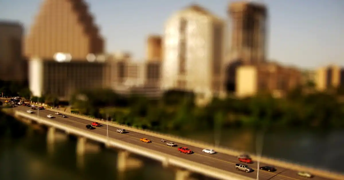 Traffic crossing a bridge in front of the downtown Austin skyline