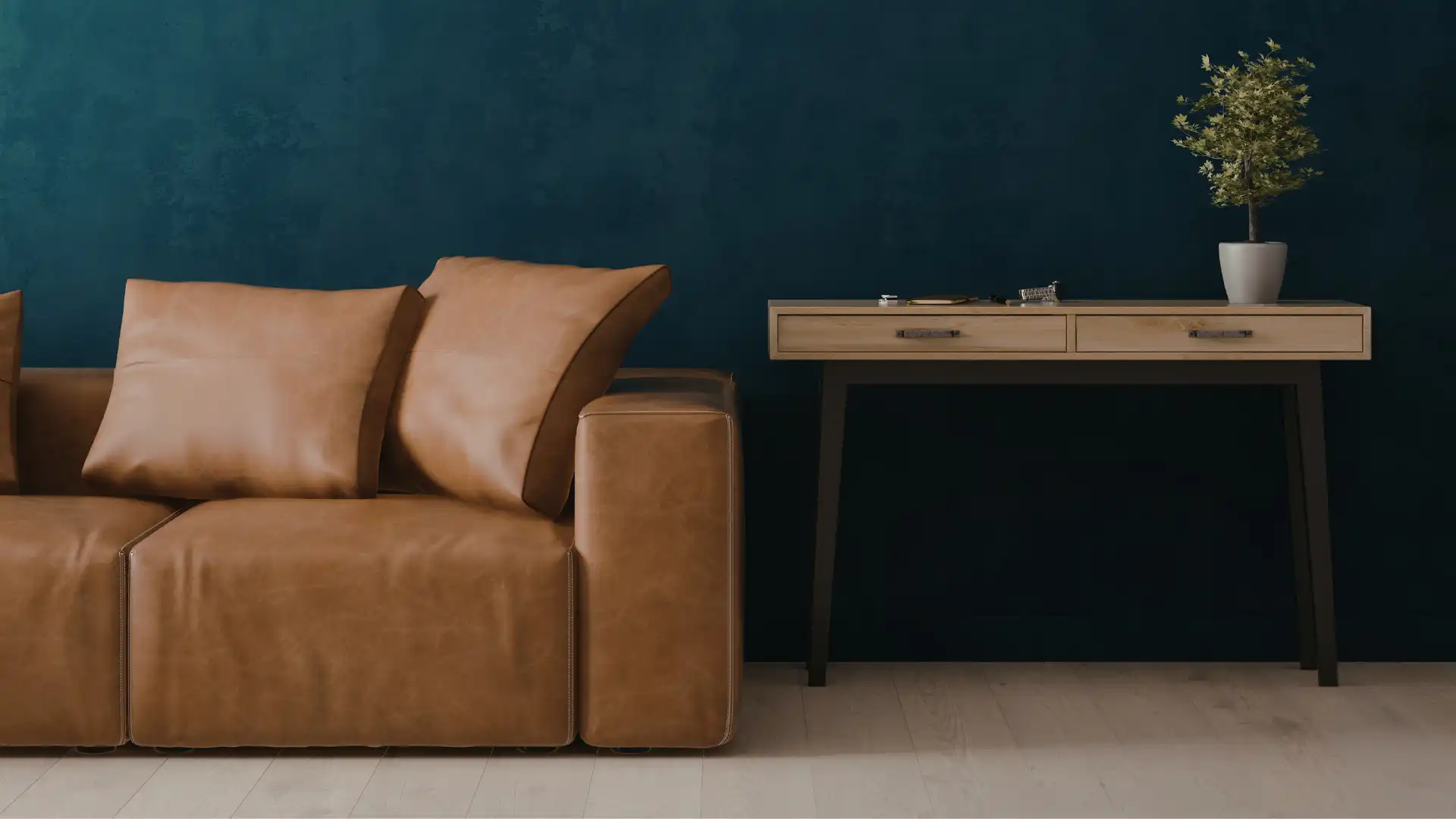 Tan leather sofa and light wood console table against a deep teal accent wall in a modern Nashville home interior