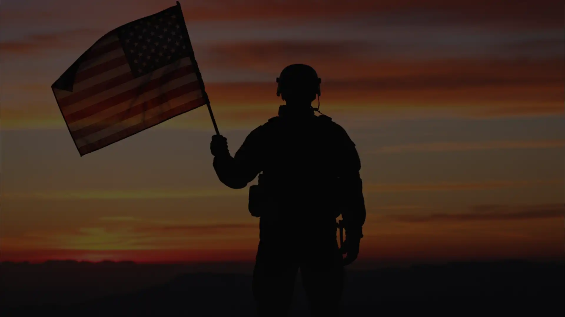 Silhouette of a U.S. service member holding an American flag at sunset, featured in a Six1Five Living blog post about VA home benefits and Middle Tennessee real estate.