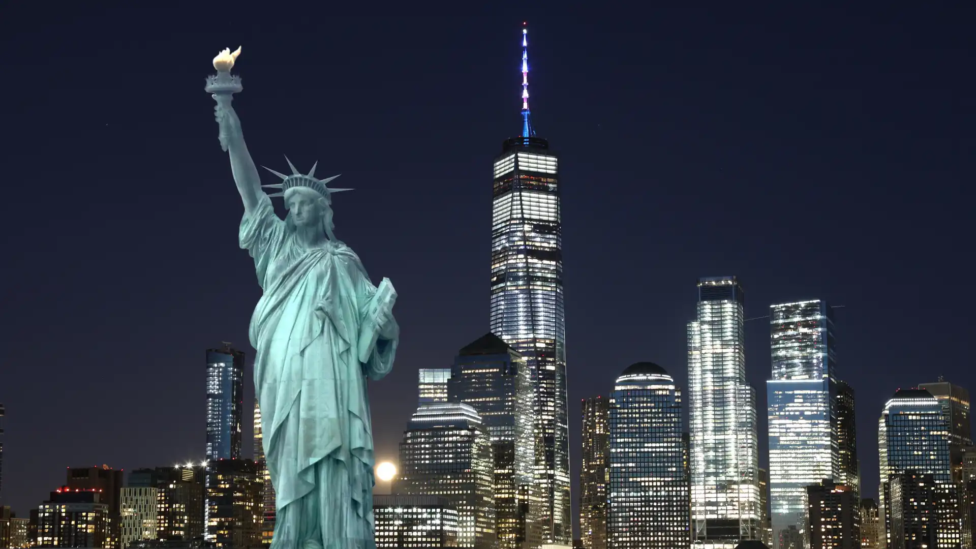 image of the Statue of Liberty with the New York City skyline at night