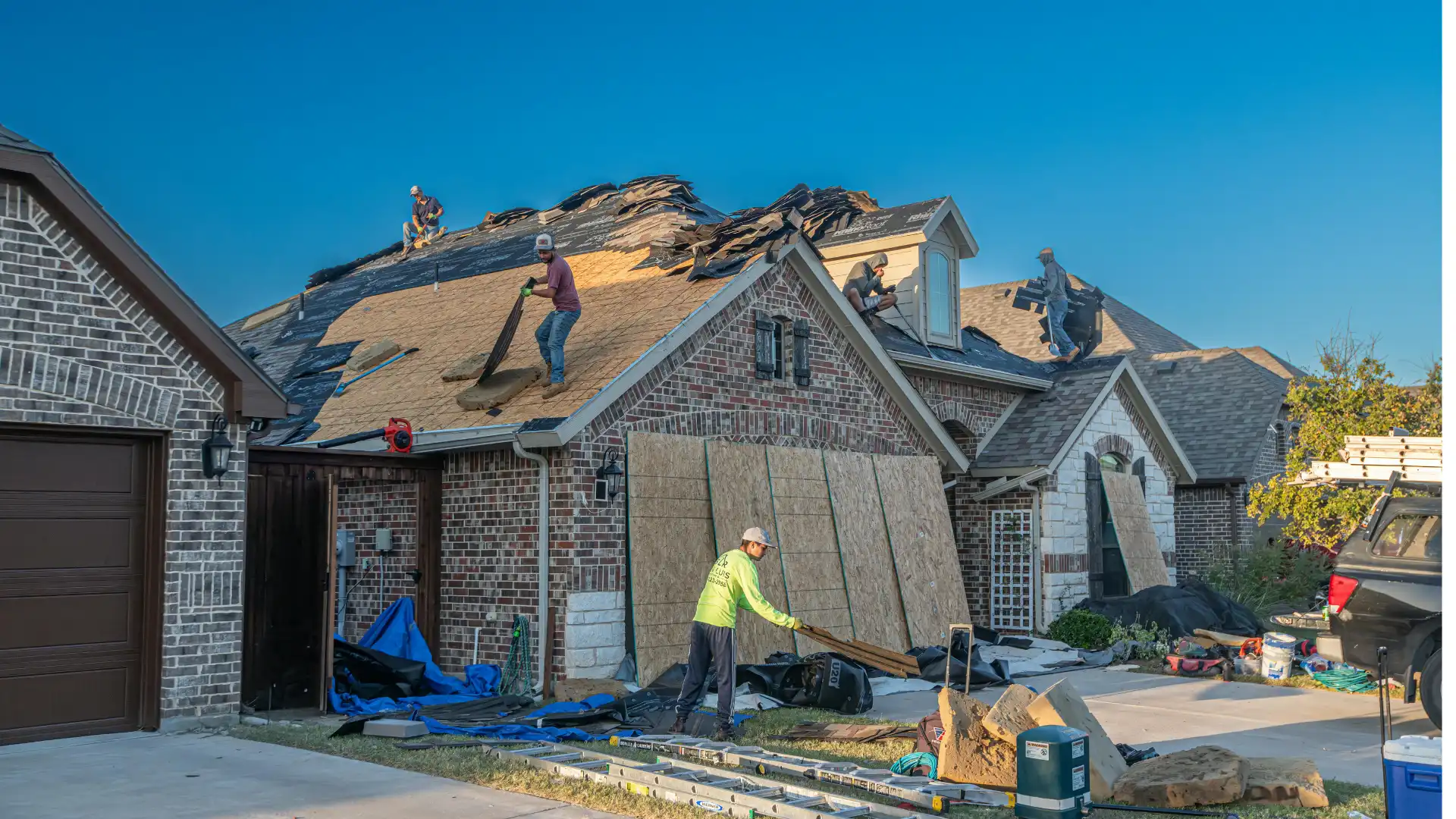 Construction workers replacing a residential roof on a brick home in a Nashville suburb representing pre-listing home repair