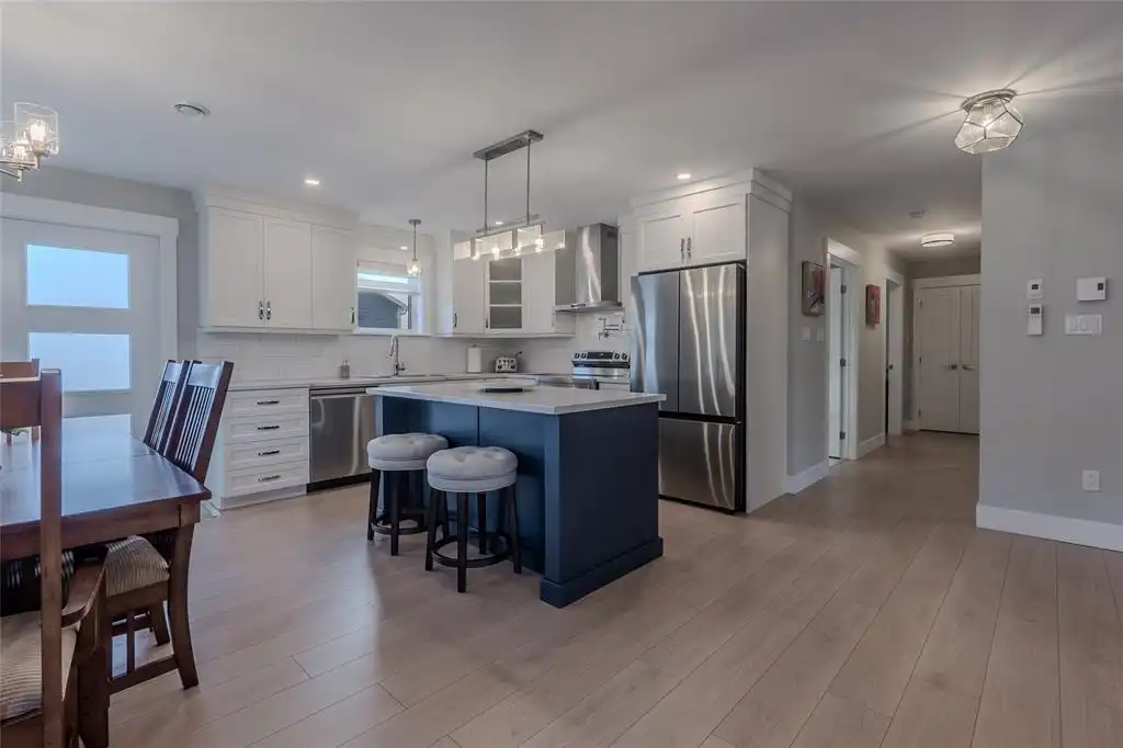 Clean kitchen with an island and adjoining dining area, prepared for real estate photography