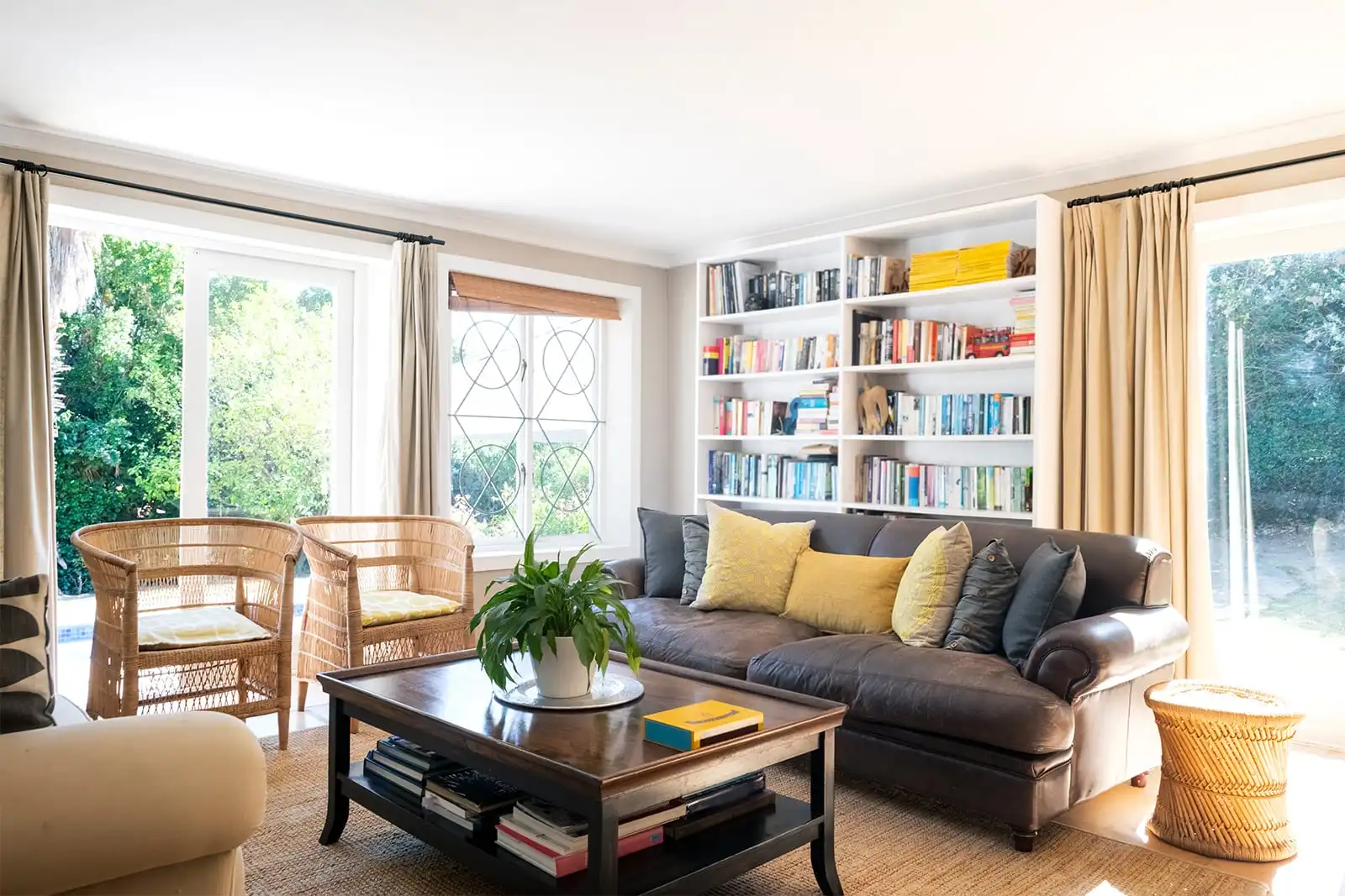 Bright living room with large windows, seating and bookshelves